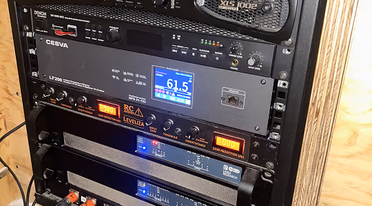 Équipement audio professionnel monté en rack avec écran numérique indiquant un niveau sonore de 61,5 dB.