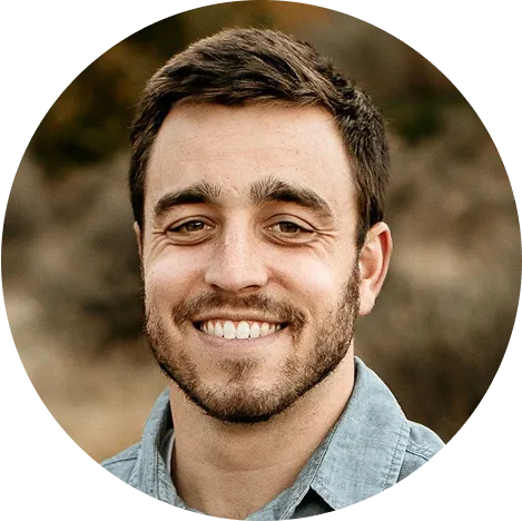 Smiling man with short beard outdoors.