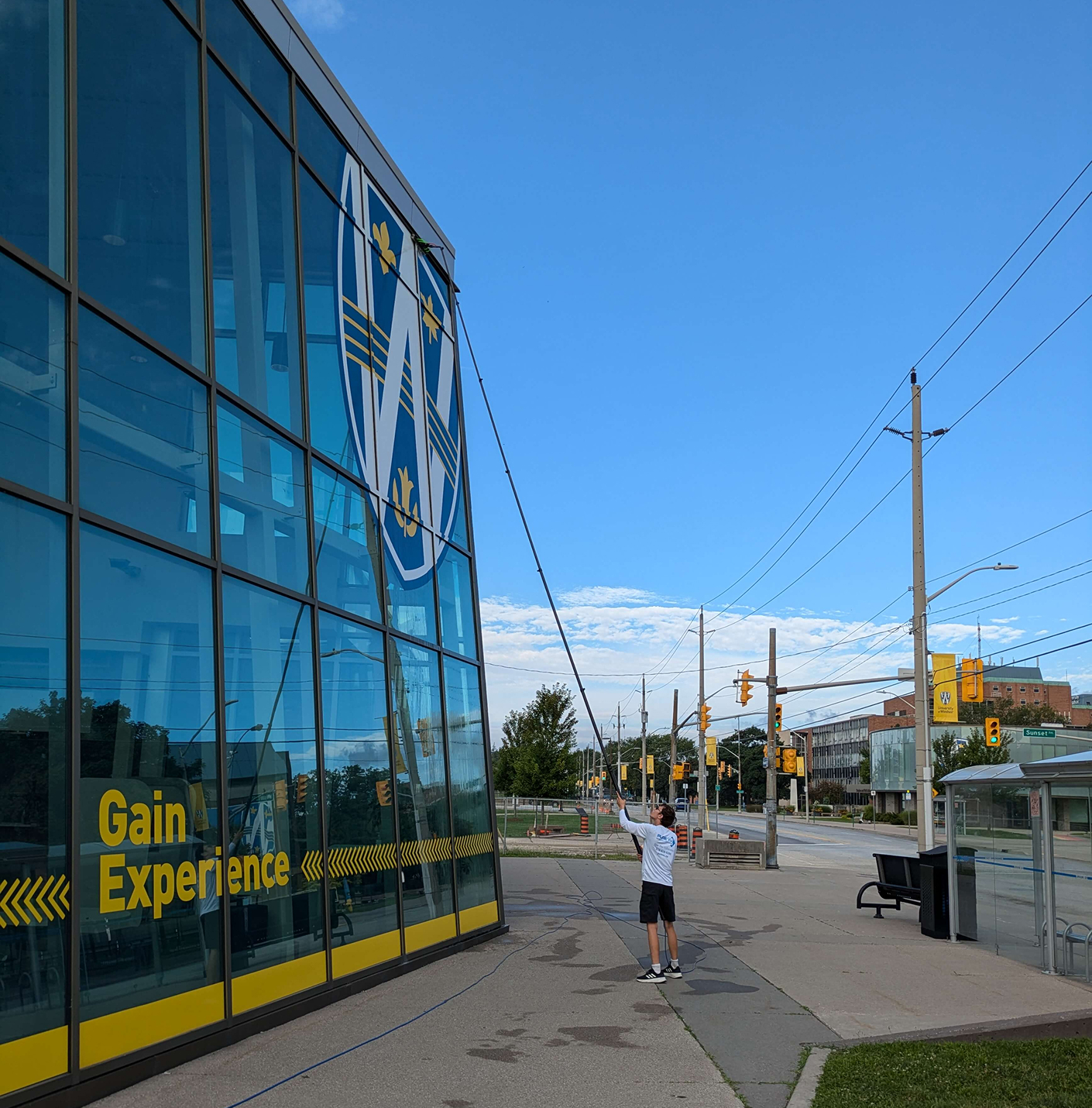 A window cleaning technician cleaning a building at University of Windsor.