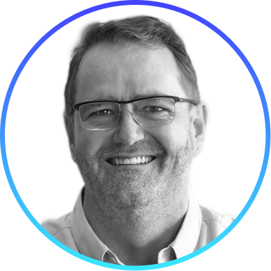 Smiling man wearing glasses and a light-colored shirt inside a circular blue gradient frame.