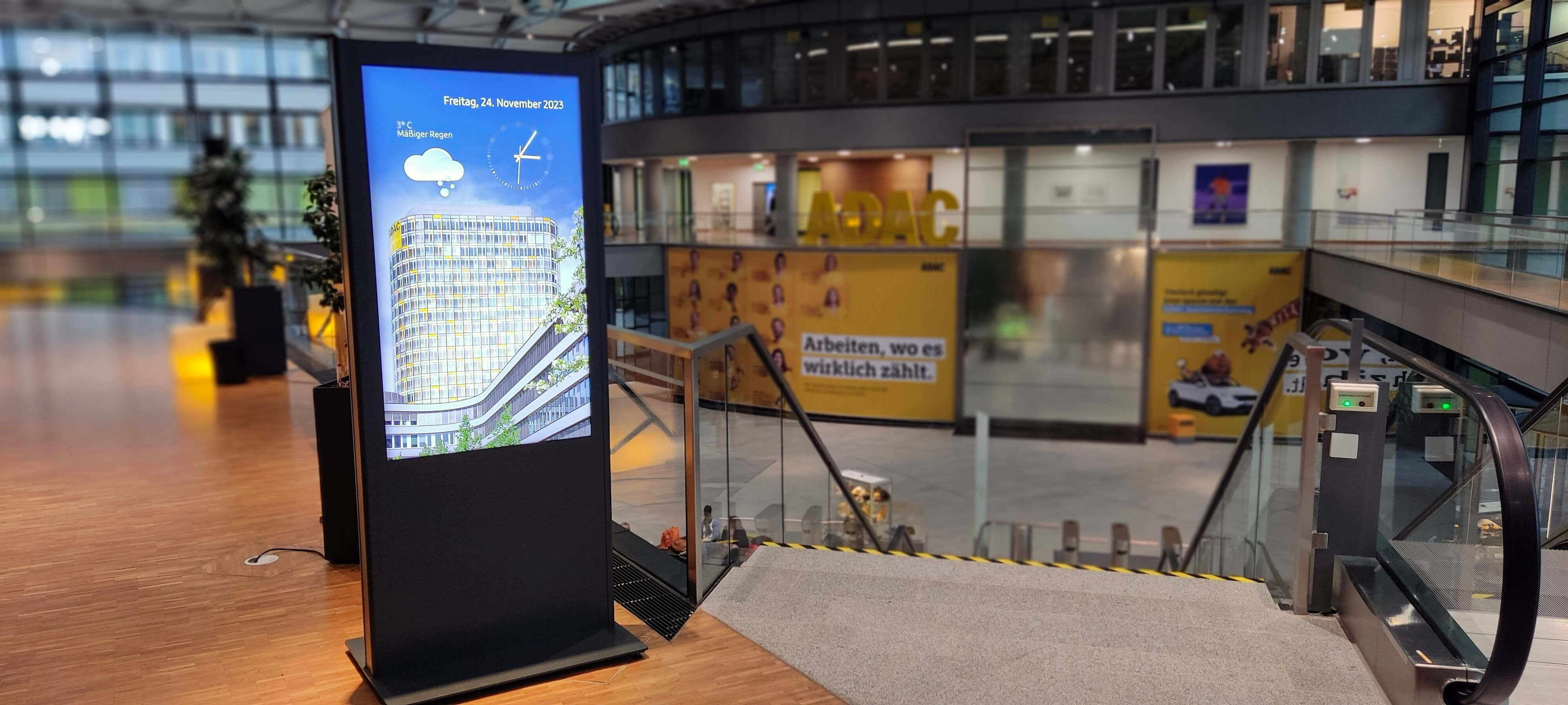 Digitale Informationsstele im ADAC Headquarter mit Digital Signage für Besucherkommunikation, Wegweisung und aktuelle Informationen.