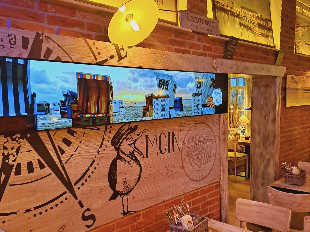 Digital signage displays at the EBBE & FLUT restaurant on Langeoog showcase menu items, special offers, and brand content for guests.