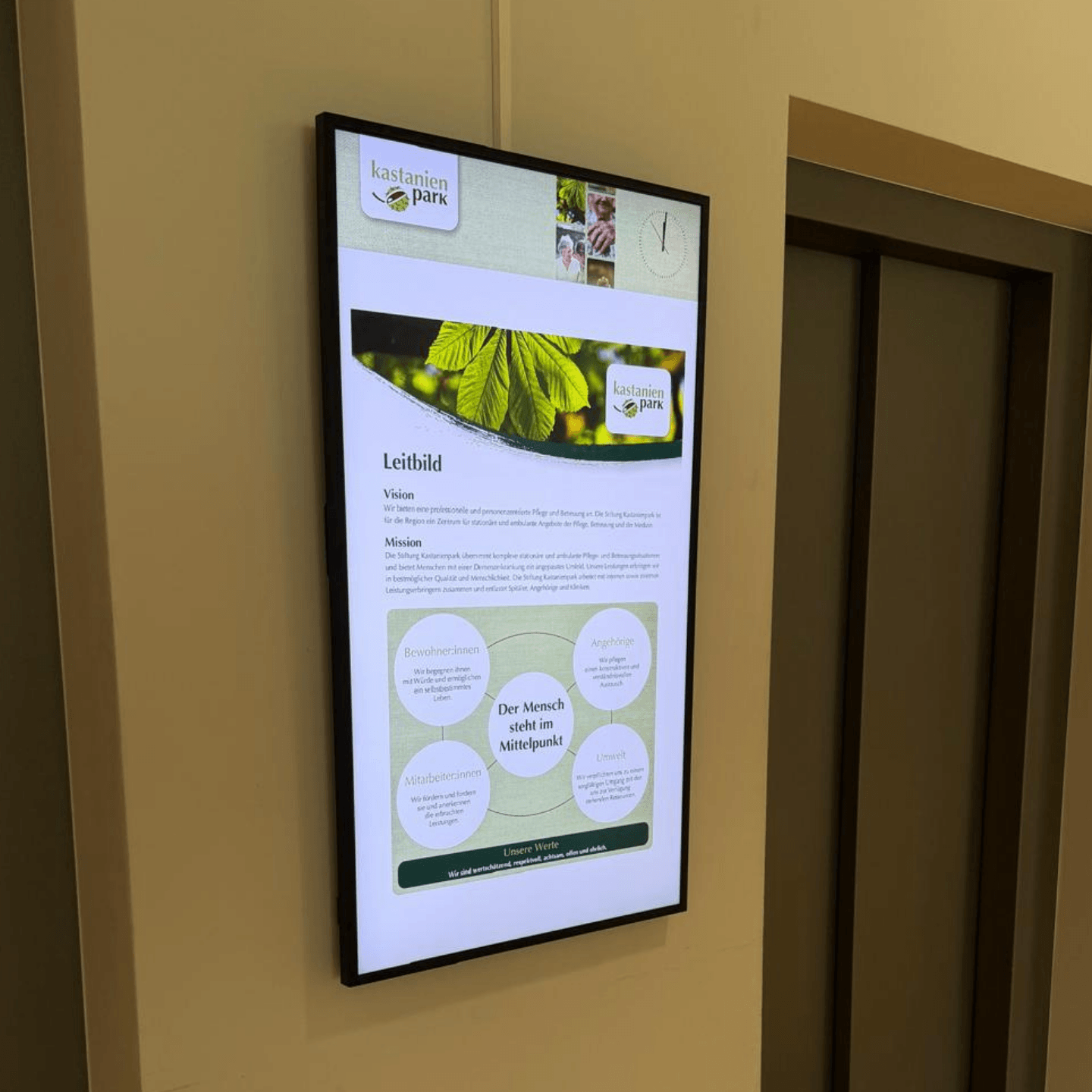 A digital signage display by the elevators at Kastanienpark shows current information for residents, visitors, and staff.