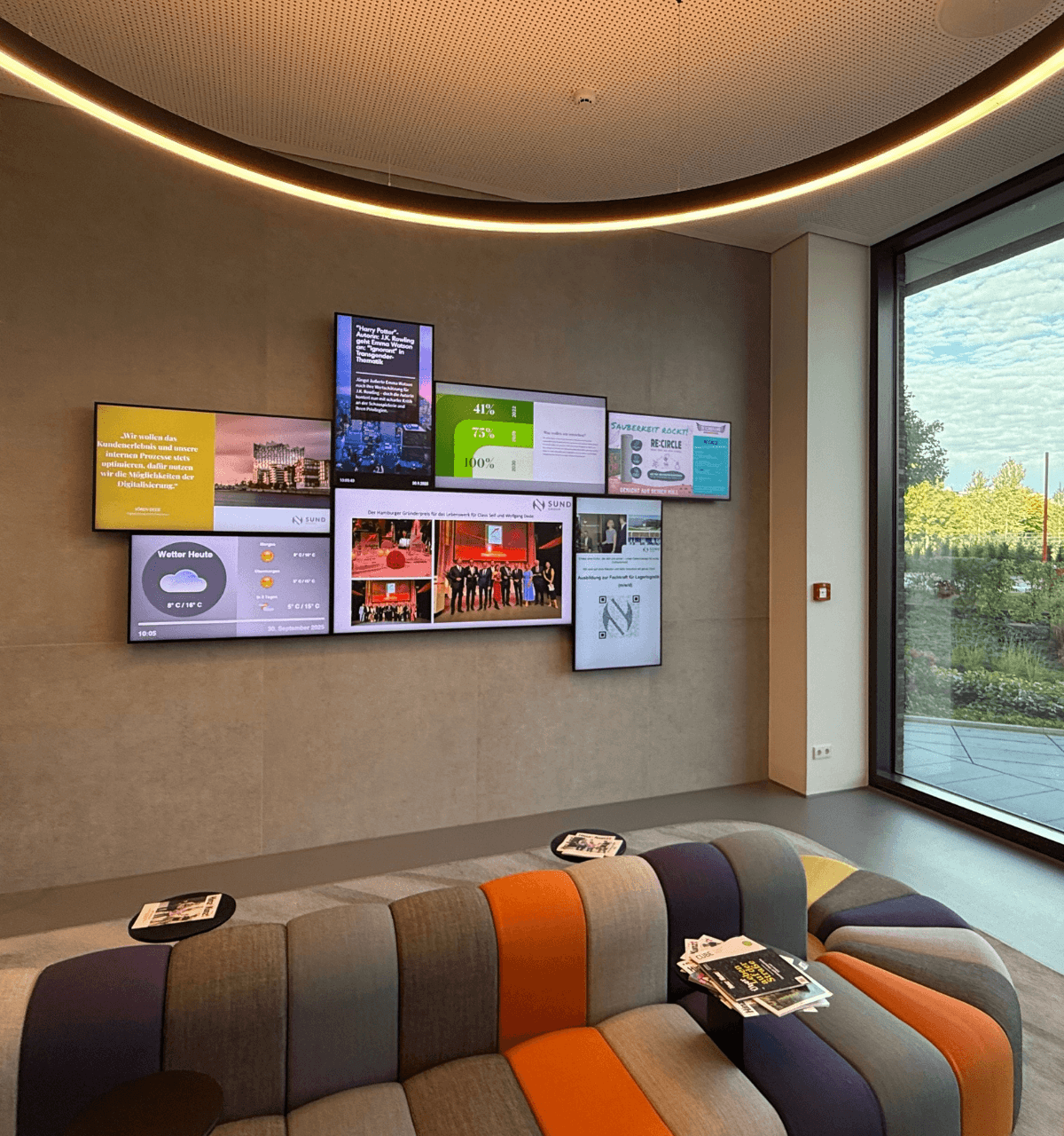 The SUND Group's digital art wall displays current information and corporate values in a modern reception area.
