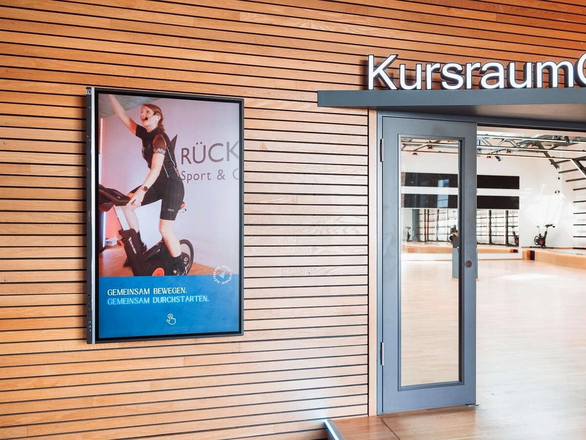 Interaktives Digital Signage Display der Rückgrat Gruppe am Eingang zum Kursraum Alter Zollhof zeigt aktuelle Fitnessinhalte