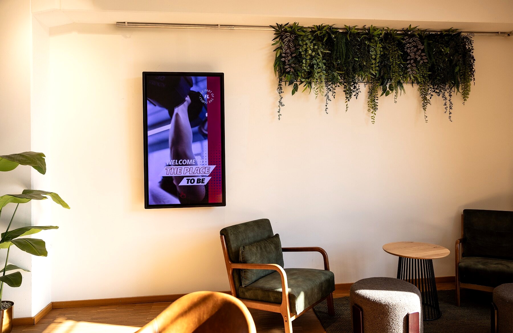 Interactive touch display at Fitness-Loft Gundelfingen Nord welcomes members in the lounge area
