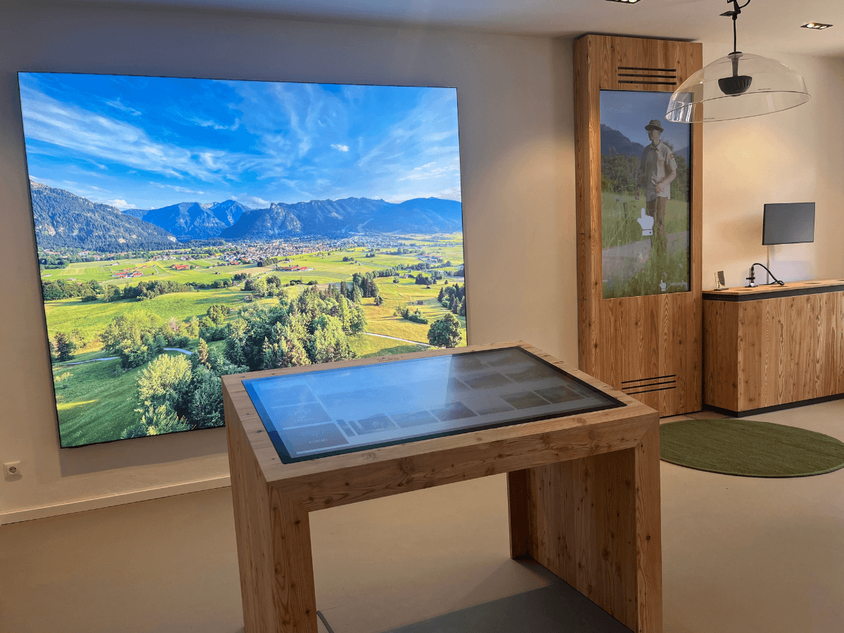 Touch-Tisch und großformatige Landschaftsanzeige in der Touristinformation der Ammergauer Alpen