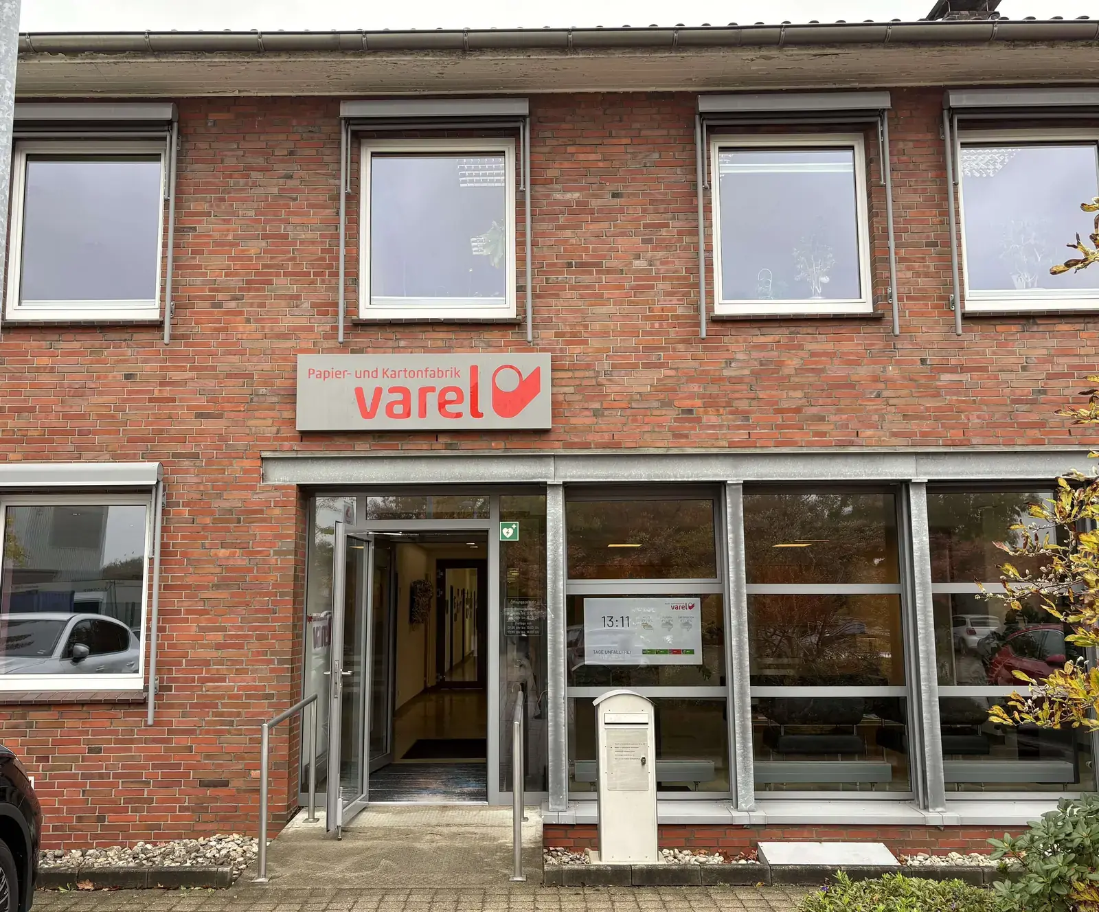 Eingangsbereich der Papier- und Kartonfabrik Varel mit einem Infodisplay hinter der Glasfront