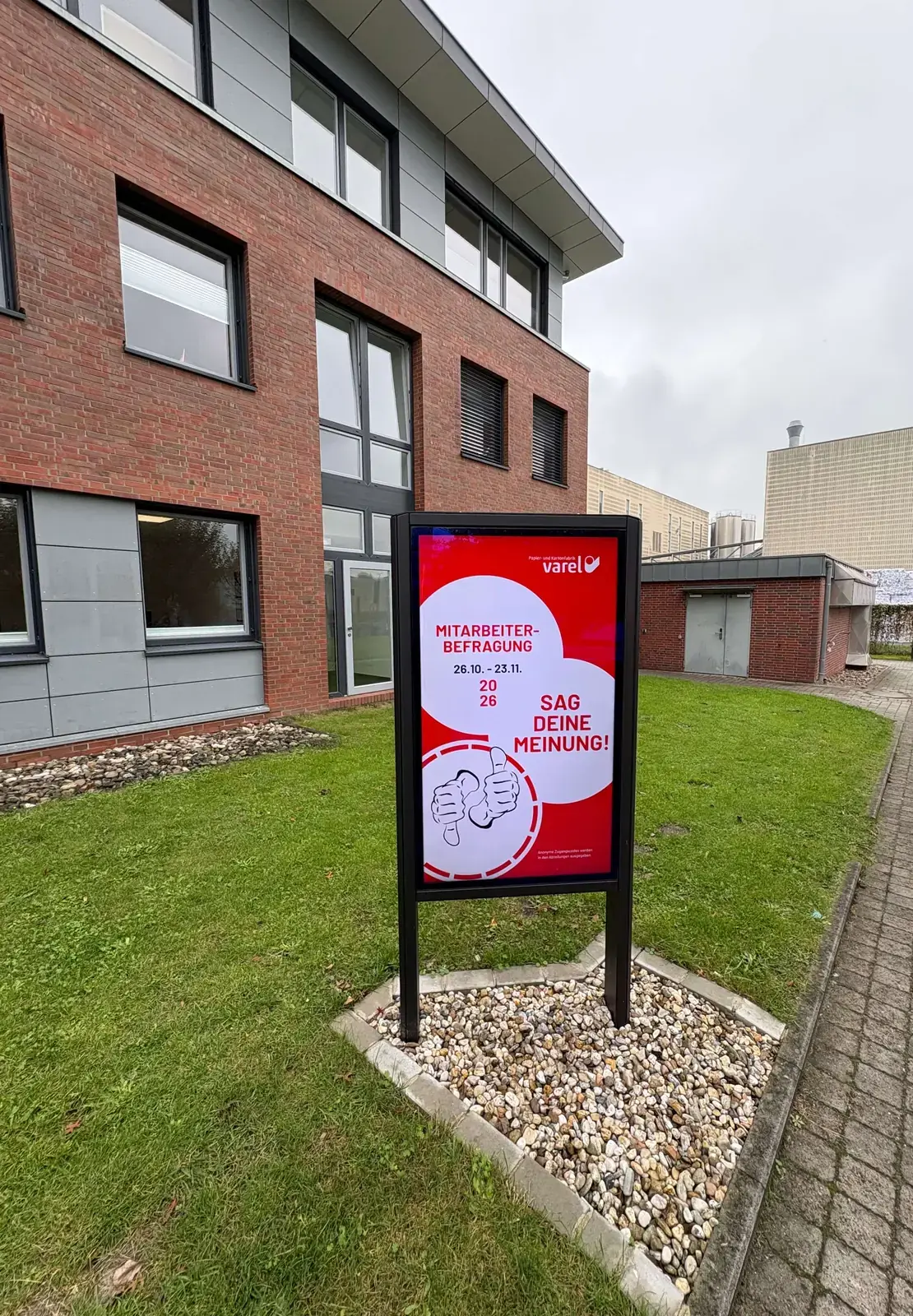 Outdoorstele der Papier- und Kartonfabrik Varel mit einer Einladung zur Mitarbeiterbefragung