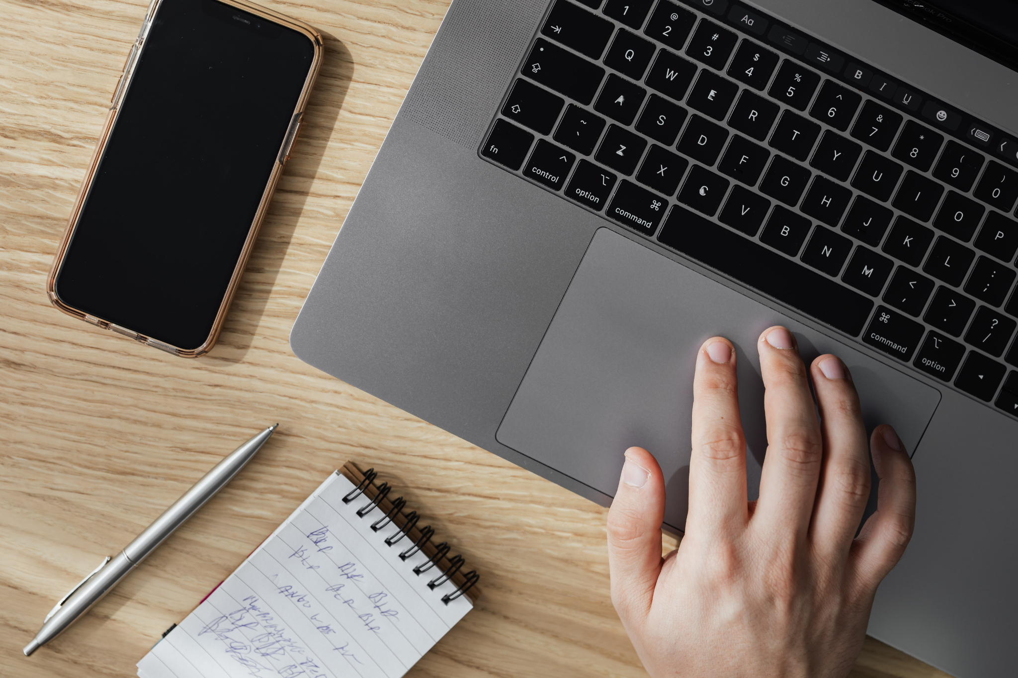 Un homme qui note les astuces qu'il lit sur son ordinateur sur son cahier