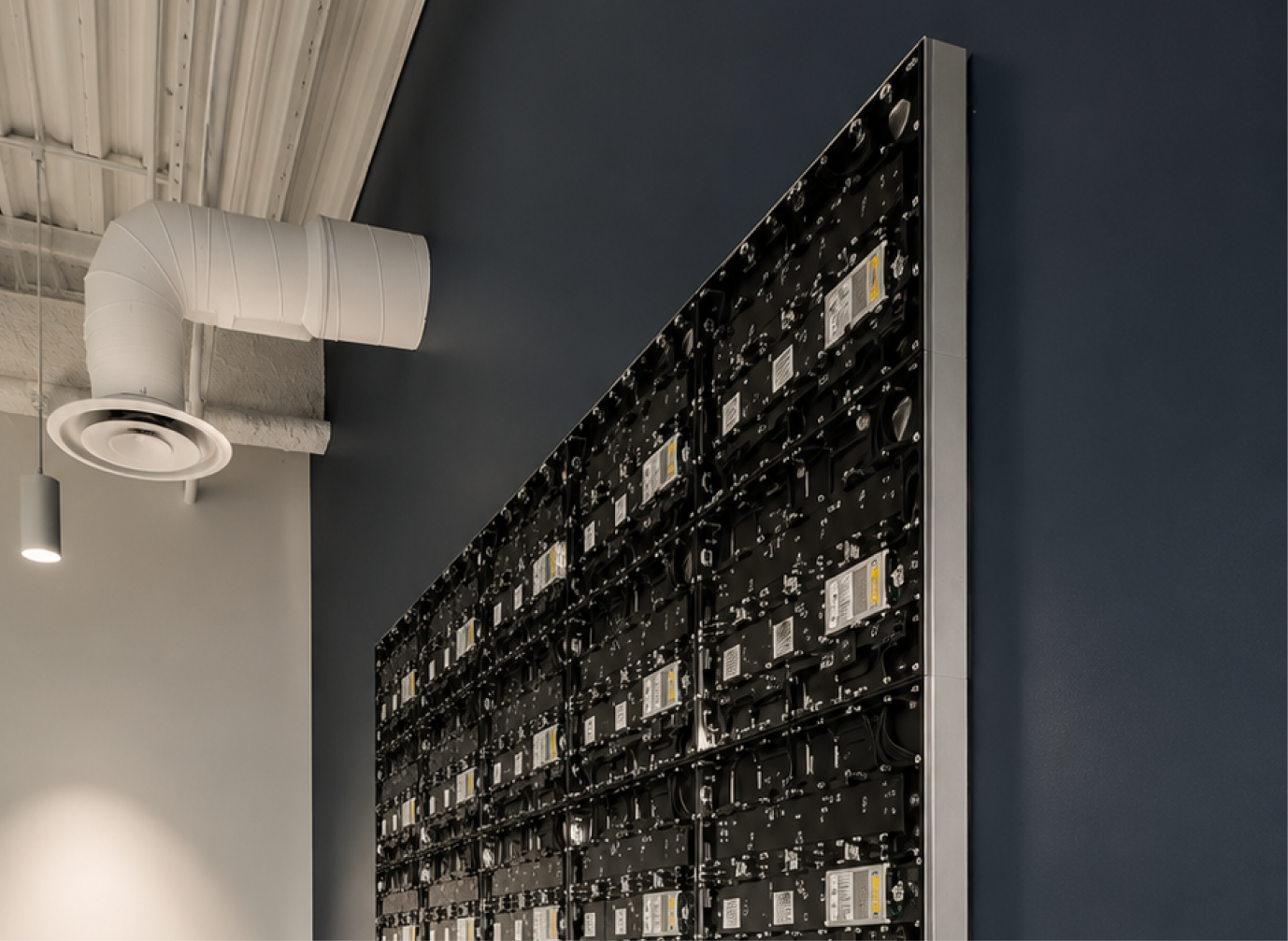 The office cafe and pantry area, a space employees pass through daily, needed a focal point that matched the quality of the surrounding design, rather than a blank wall or a standard TV in a space built for informal gathering.