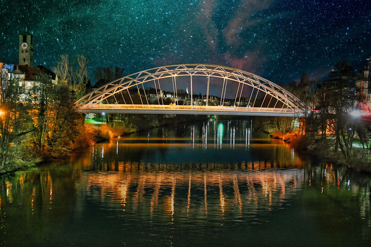 Kettenbrücke in Bamberg bei Nacht unter dem Sternenhimmel, gespiegelt in der Regnitz