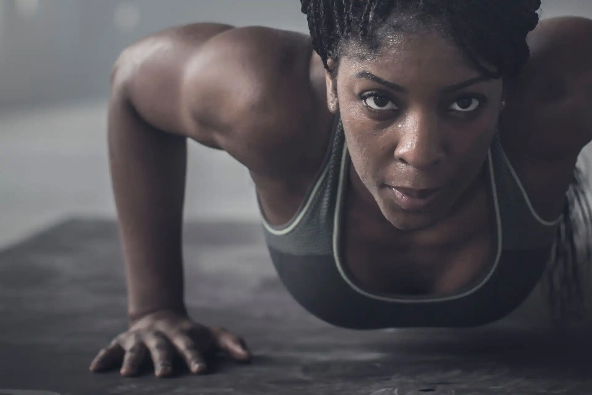 Close-up of a focused woman doing a push-up on a mat.