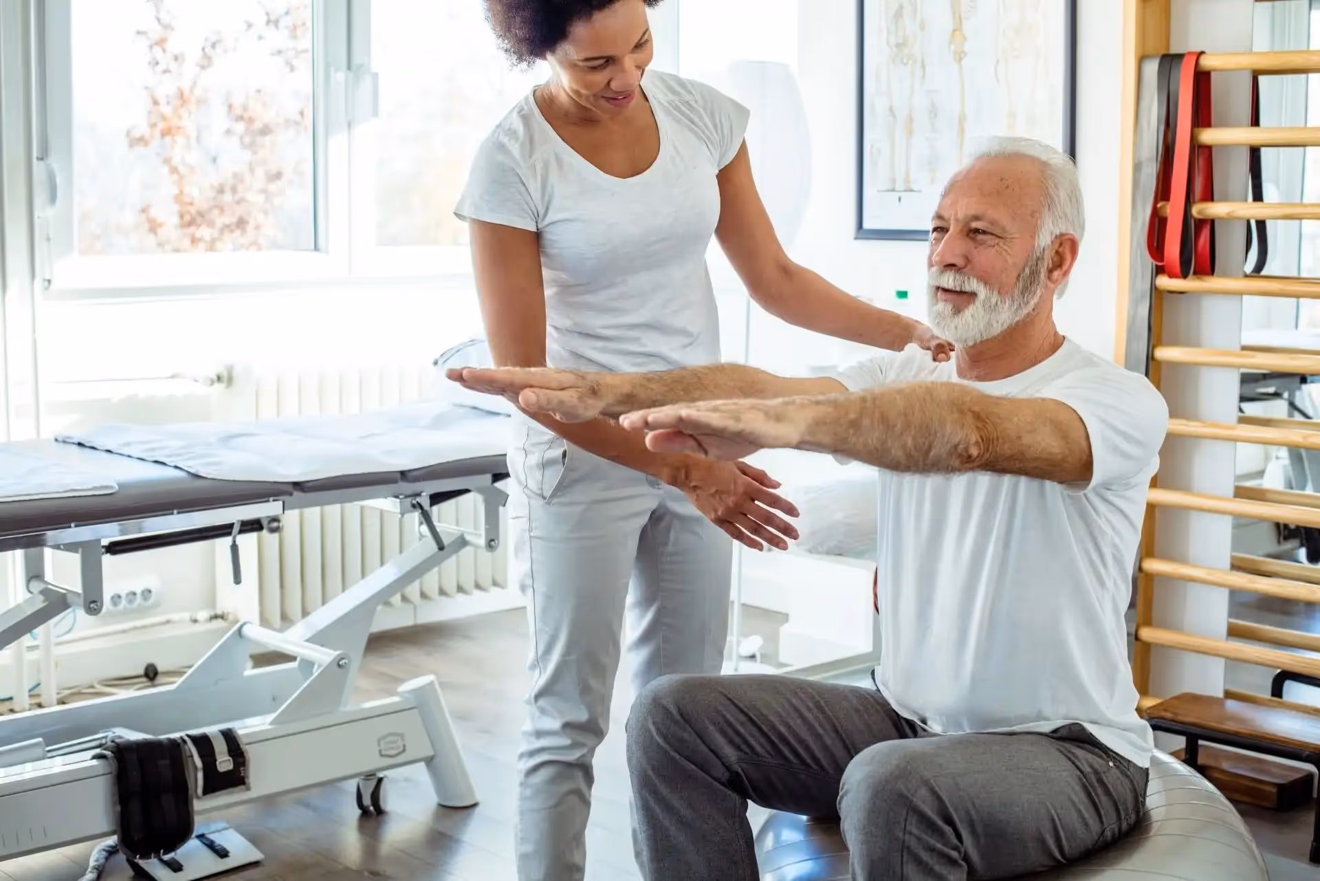 A physiotherapist treating and older man.
