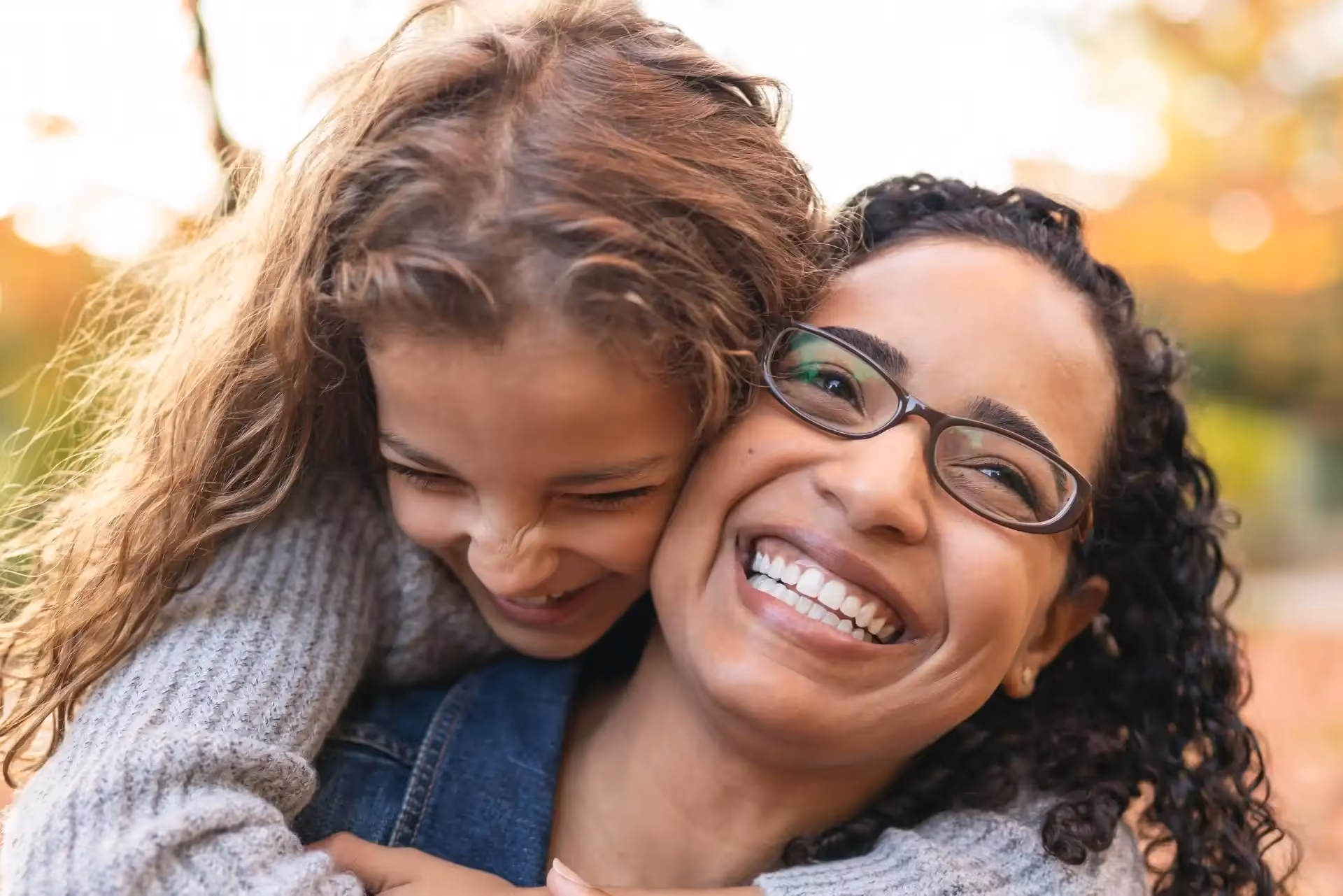 Two women with white teeth smiling.