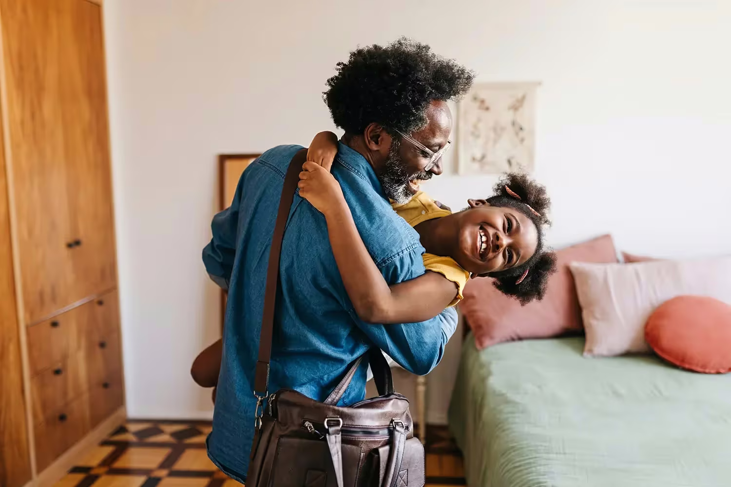 A father arriving home and embracing his daughter in a warm hug, both smiling