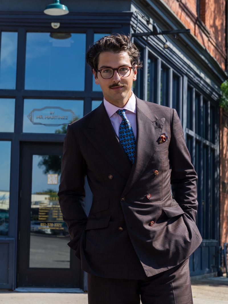 Bespoke brown double-breasted suit, portrait outside a storefront