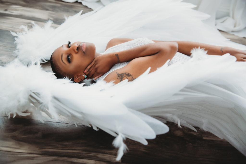 Woman in angel wings on wooden floor; Creativity fosters creativity; boson boudoir by Lindsay Hite