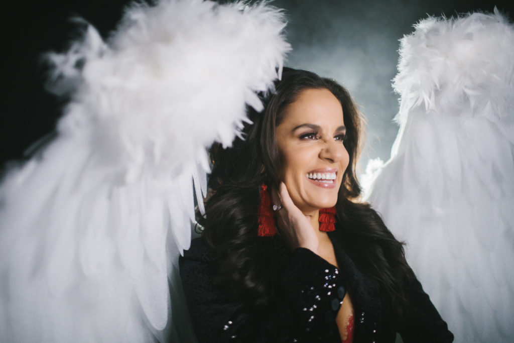 Woman in power suite and white angel wings; self care: an investment in future generations; photography by Lindsay Hite