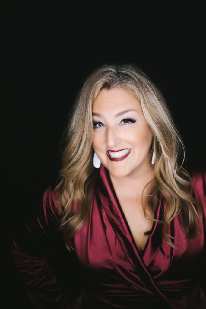 Boston-Area Luxury Photography Studio, Hair and Makeup Artist Michelle DeVoe in red wrap dress against a black background