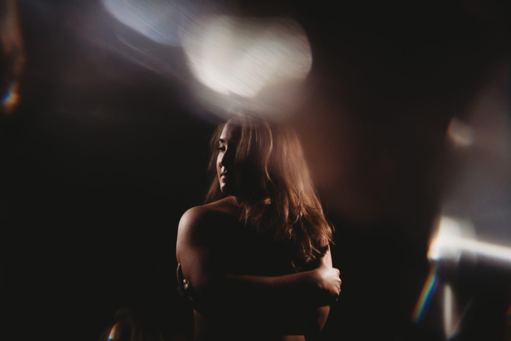 Woman nude in a meditative statewith a dark background.  Learning to Live an Embodied Life.  Photography by Lindsay Hite