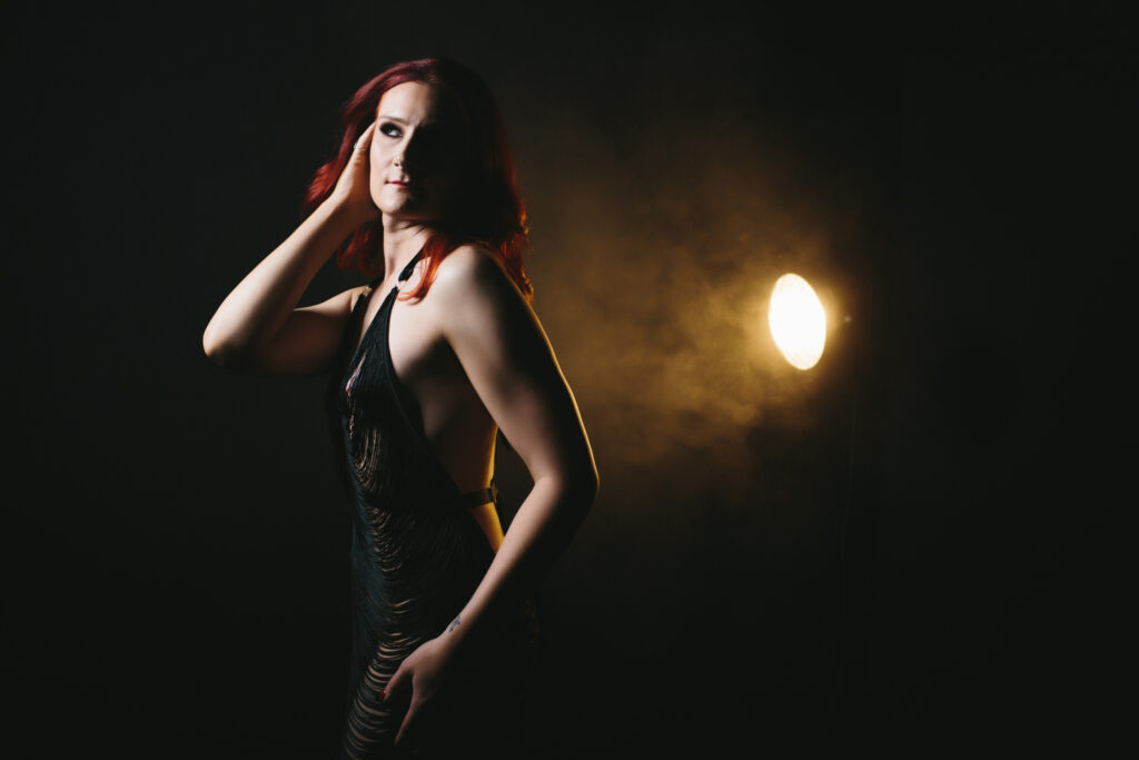 Woman in black fringe dress with a smoky black background. Boudoir photography by Lindsay Hite. 