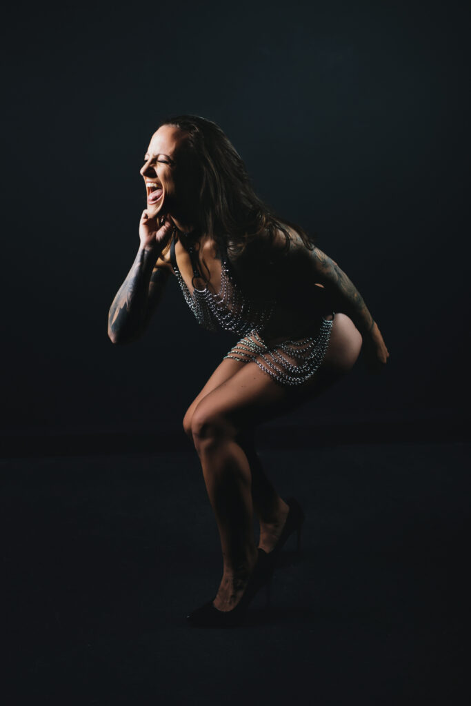 Woman wearing chains, representing self-trust, with a look of joy and fierceness on her face.  Photography by Lindsay Hite