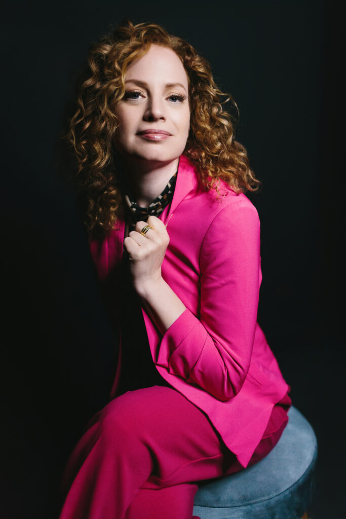 Woman in bright pink suit and leopard print shirt showing off lessons she's learn from adversity.  Photography by Lindsay Hite