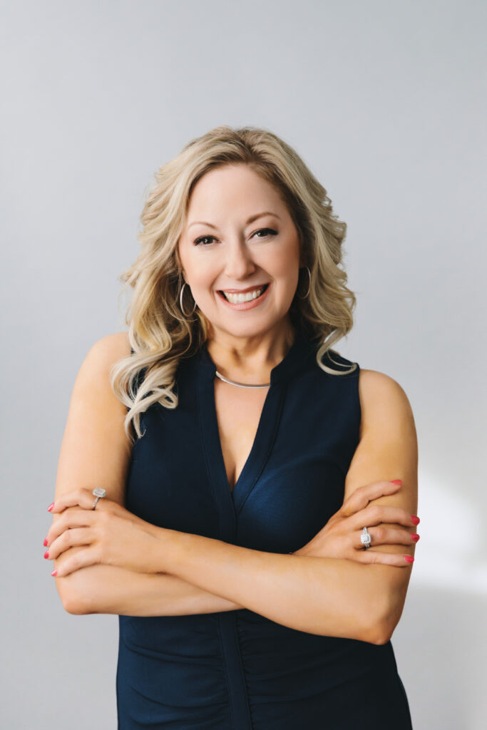 Headshop of a blonde woman with a navy sleeveless top. Photography by Lindsay Hite.