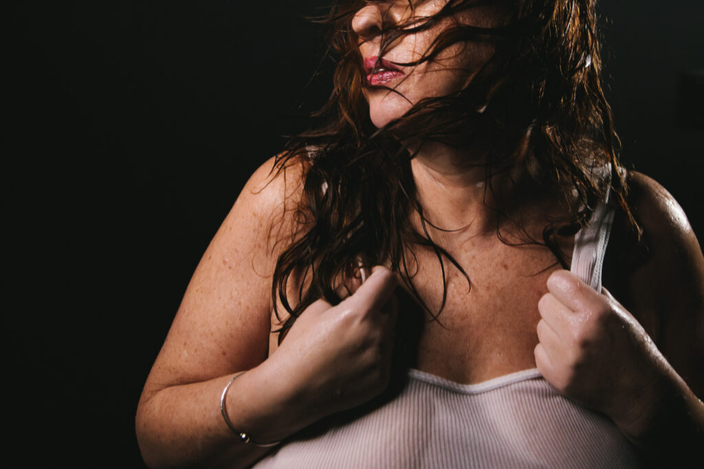 Woman in white t-shirt with a black backdrop. Photography by Lindsay Hite celebrating women over forty.