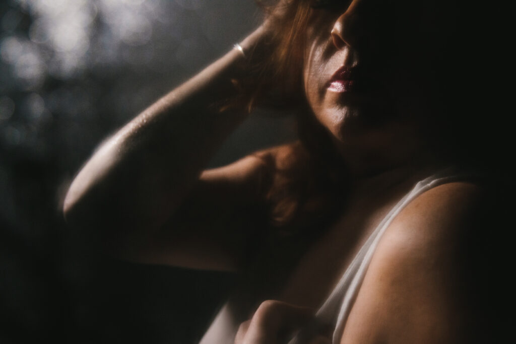 Woman in white t-shirt with a black backdrop. Photography by Lindsay Hite celebrating women over forty.