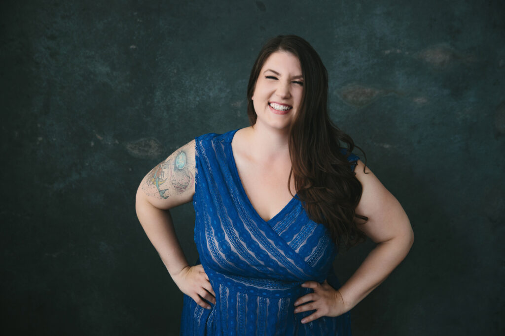 Woman in blue sundress against a headshot backdrop. Photography by Lindsay Hite