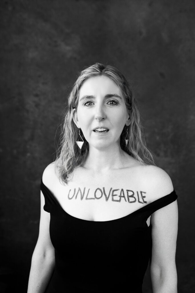 Woman with unloveable written on her chest. Photography by Lindsay Hite.