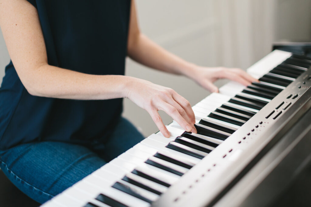 Woman's hands on a piano. Photography by Lindsay Hite