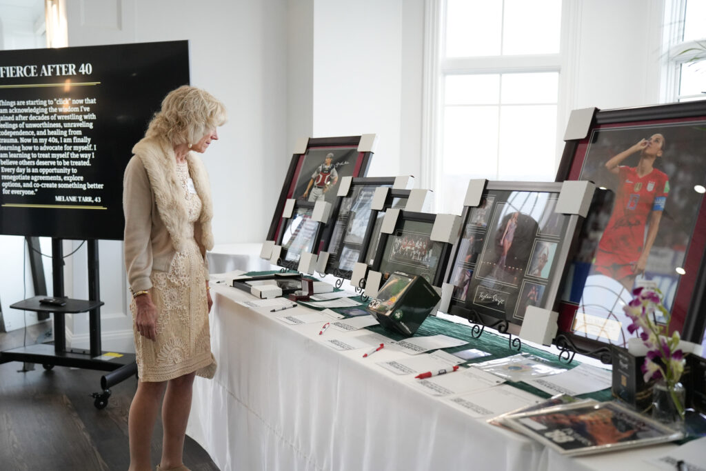 Attendee perusing the sports memorabilia. Silent Auction items to support DOVE at the Show Your Spark Gala. Photography by Nicole Chan.