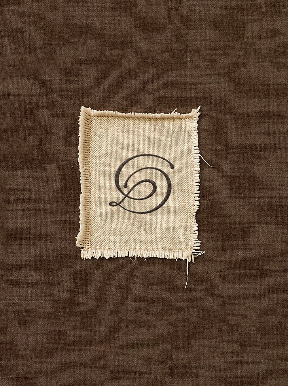 Bout de tissu sur fond marron avec un monogramme D et C
