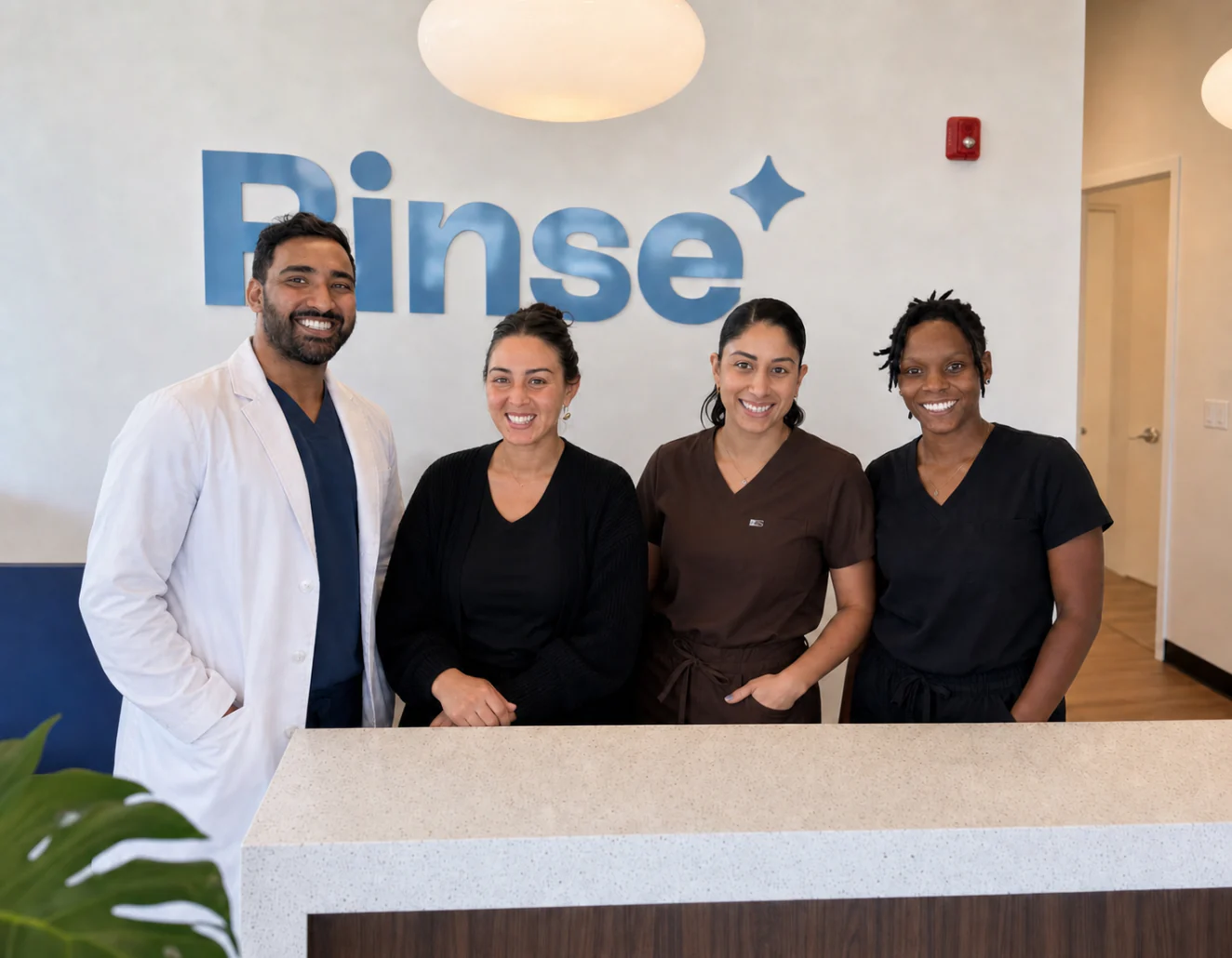 Dr. Sajan Parag with the Rinse Dental team at the reception desk