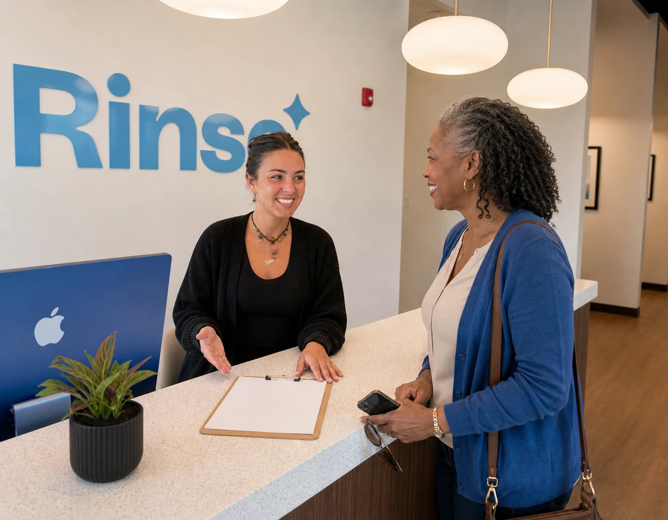 Rinse Dental team member welcoming a patient at the front desk