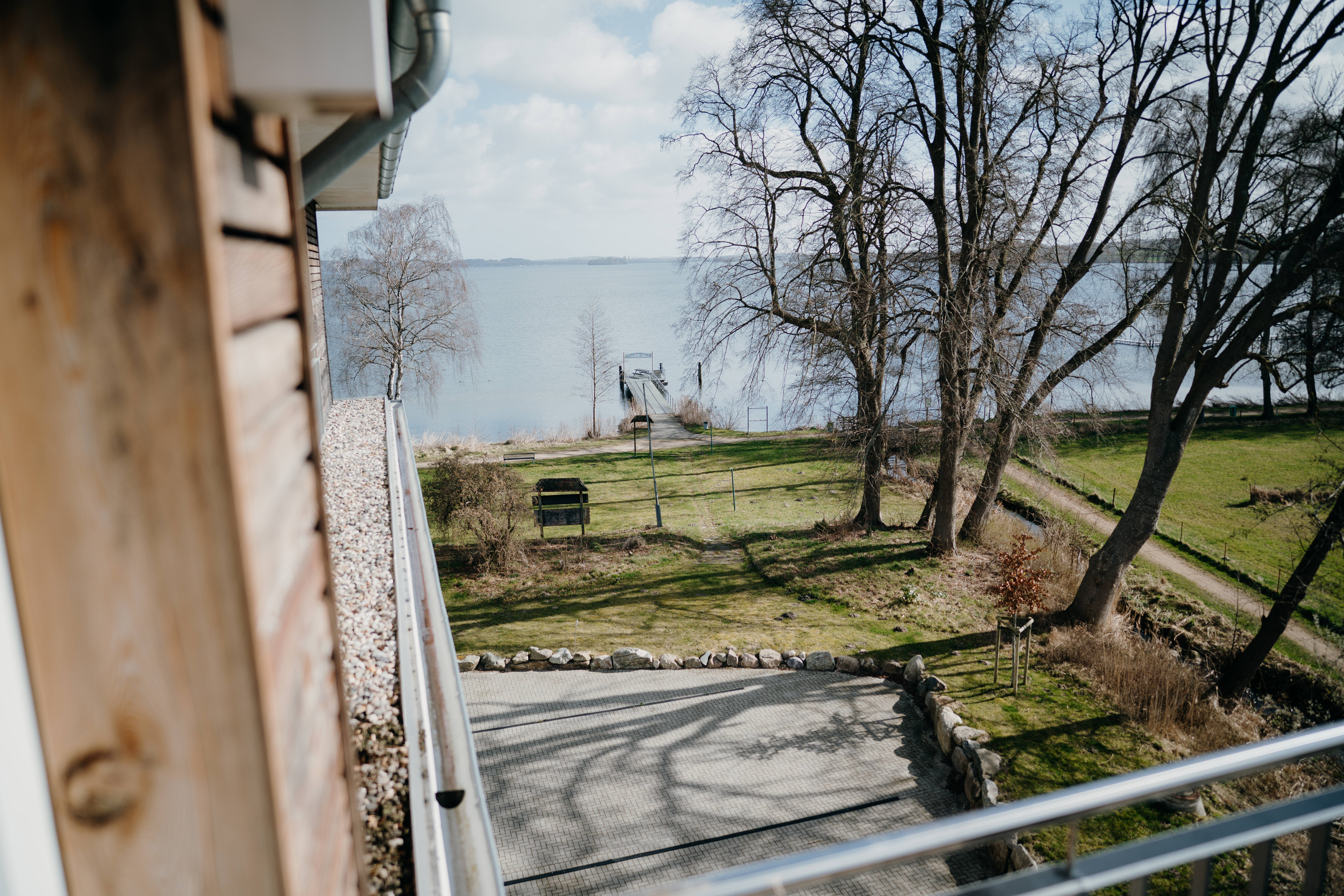 Blick vom Balkon der Ferienwohnung Seeverzaubert in Dersau über die kahlen Uferbäume auf den Großen Plöner See