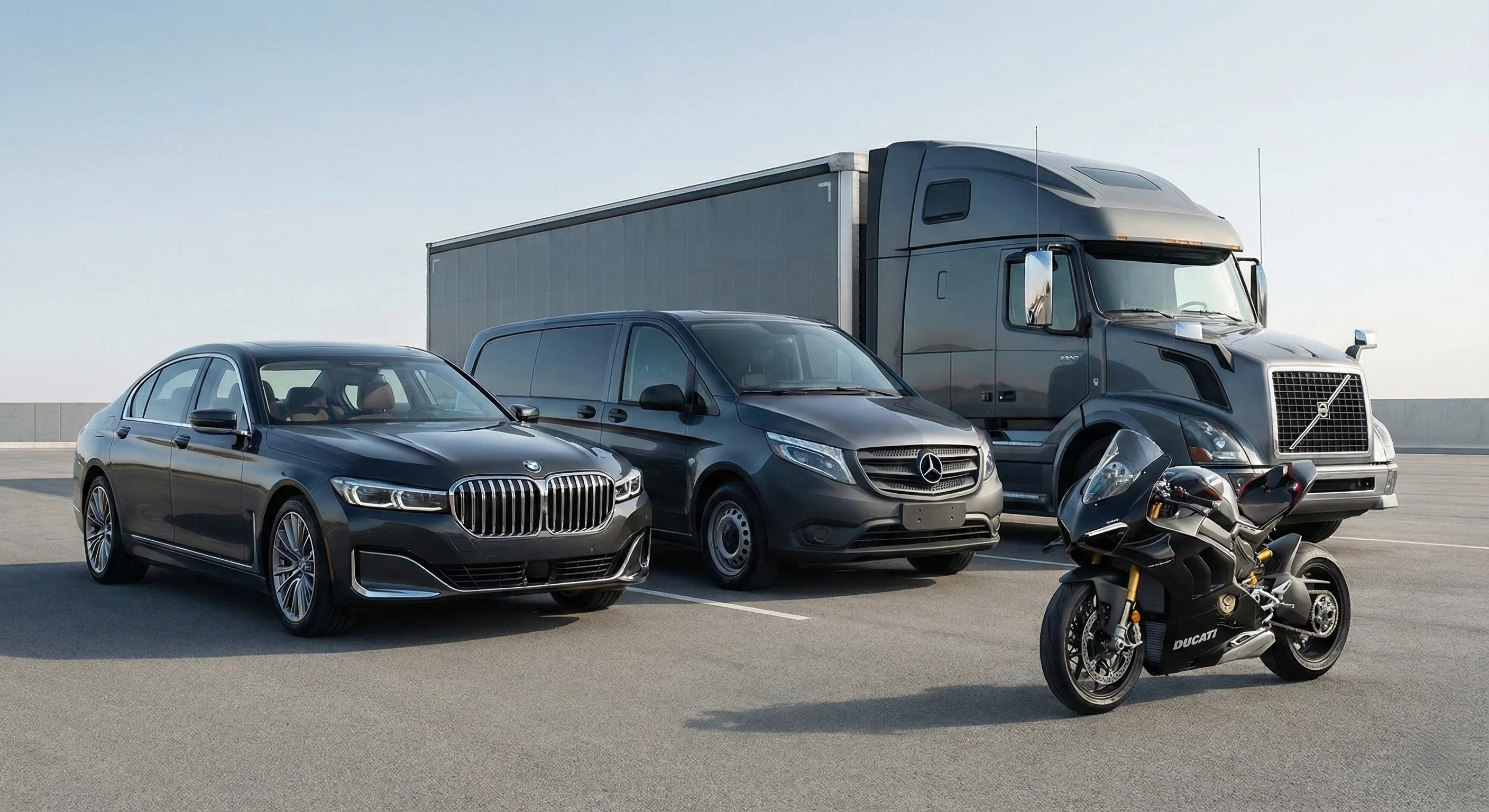 Black BMW sedan, black Mercedes van, gray Volvo semi-truck, and black Ducati motorcycle parked side by side on a flat paved surface under clear sky.