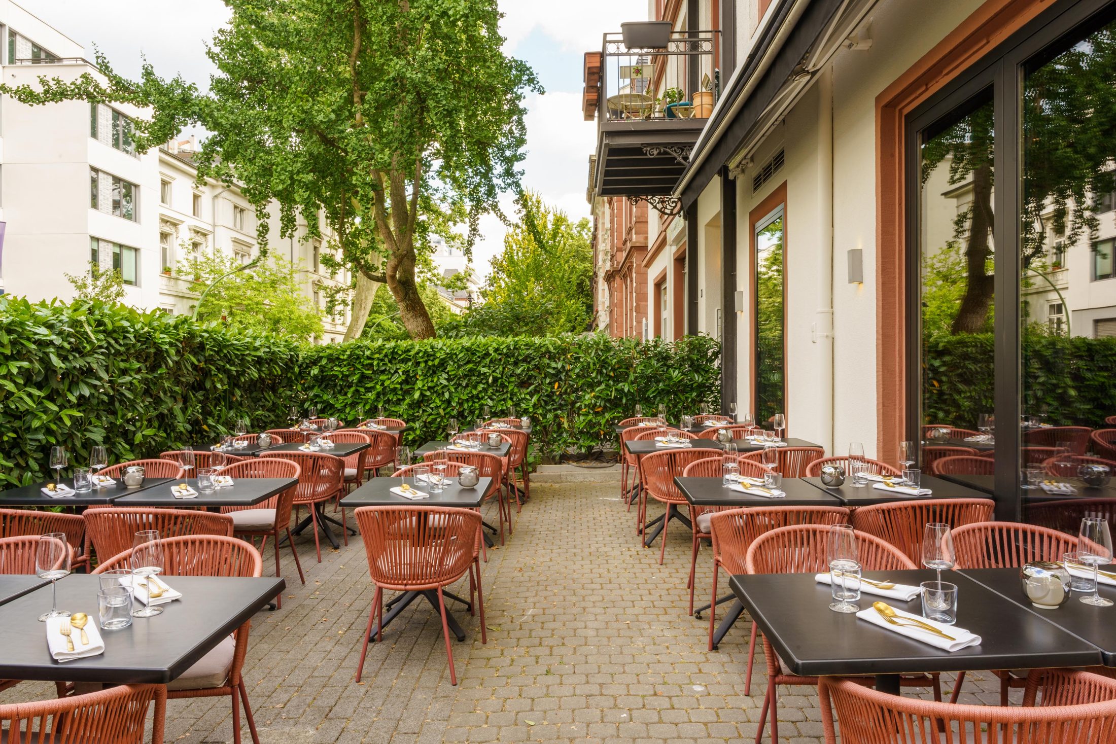 The full garden terrace at Umbra, laid for dinner