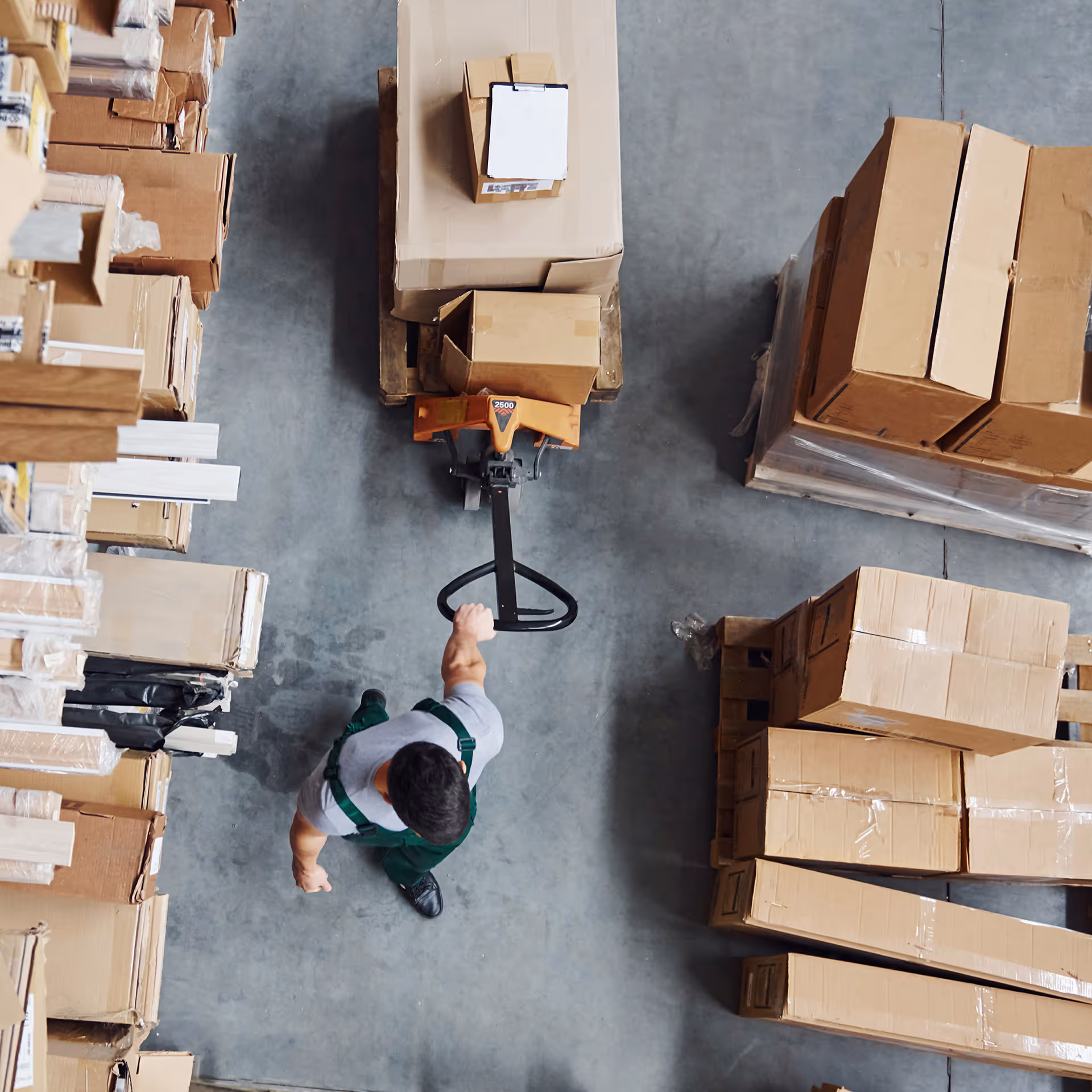 Worker with pallet jack moving boxes