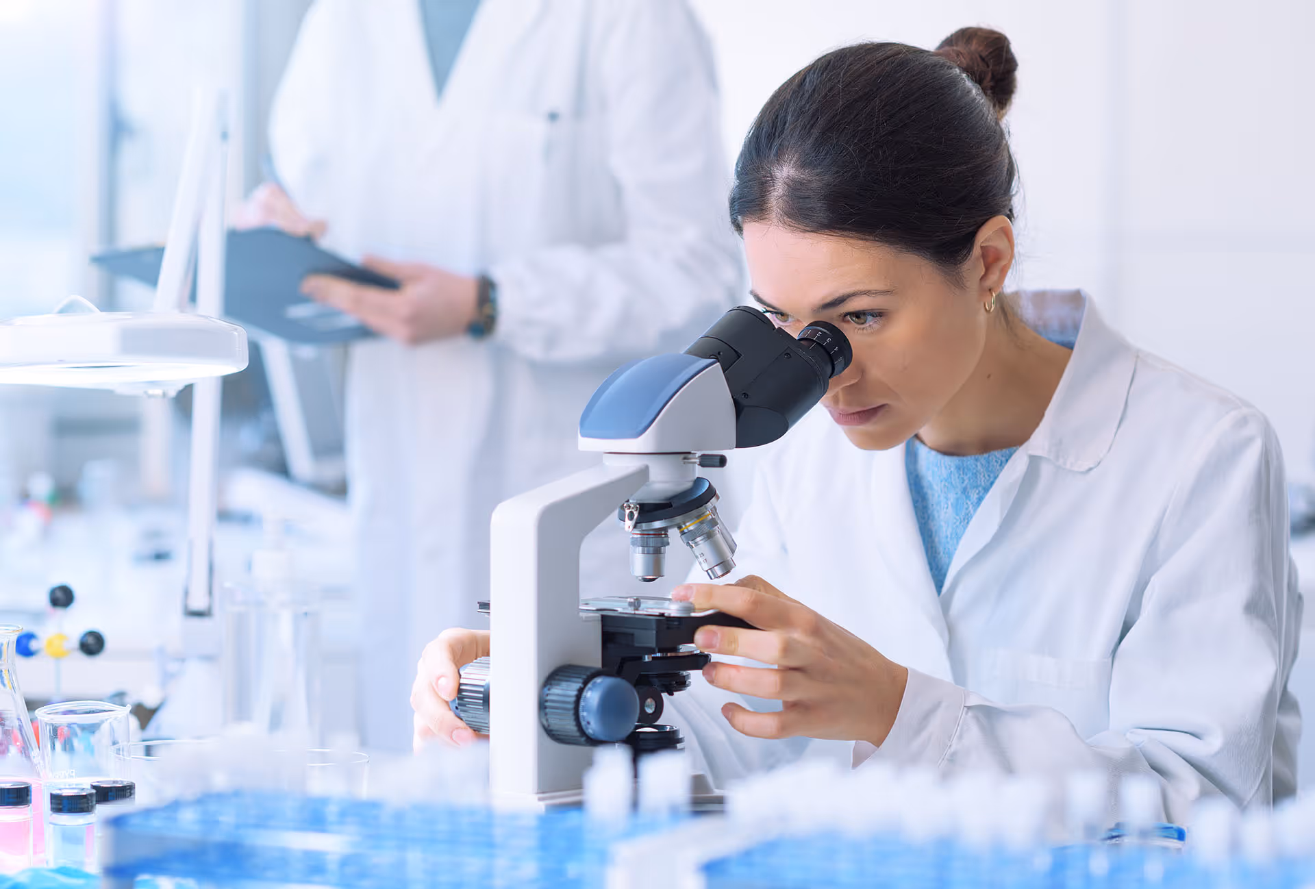 Biotech scientist with microscope.