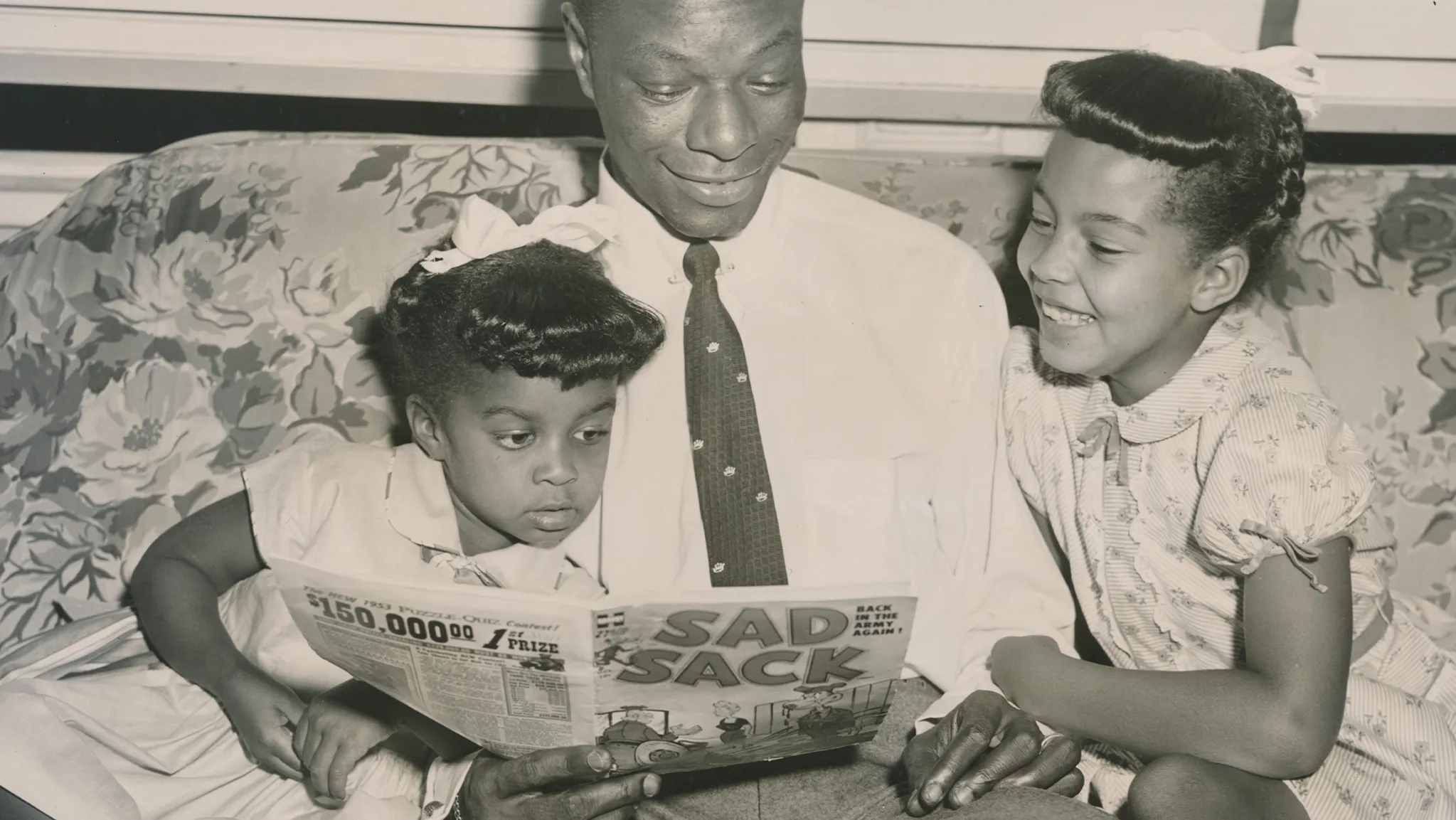 Nat Cole reads to young Carole and Natalie
