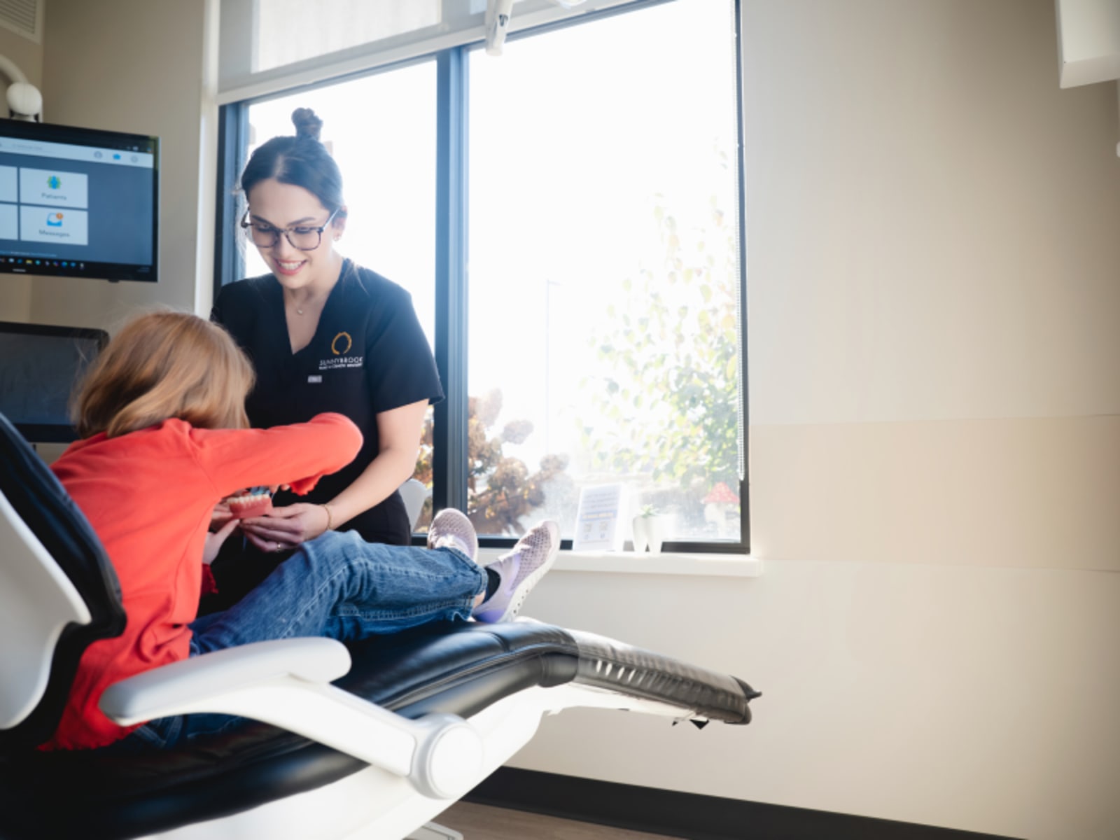 Dentist examining child patient in clinical setting