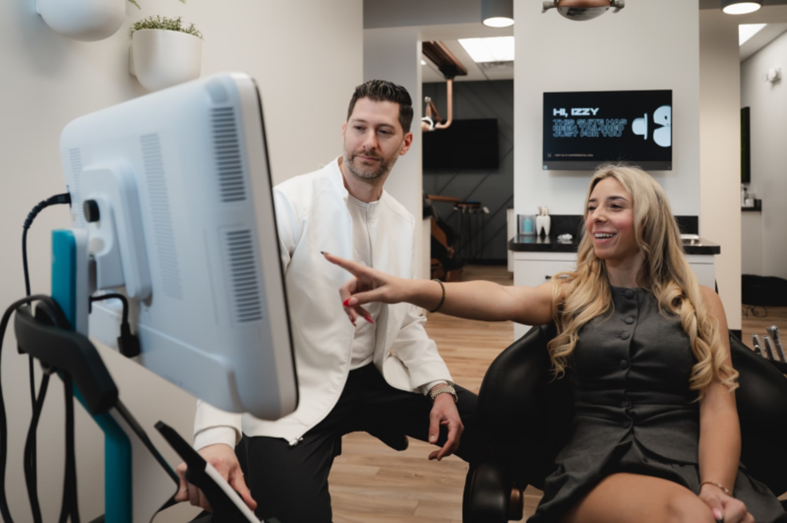 Dentist showing digital scan results to female patient during Invisalign consultation.