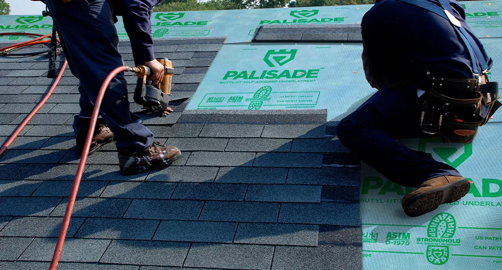 Two men working at Exterior Techs installing a new asphalt shingle roof.