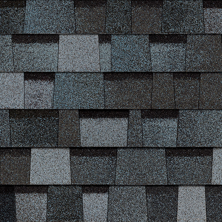 Close-up of blue and gray asphalt shingles arranged in a layered pattern.