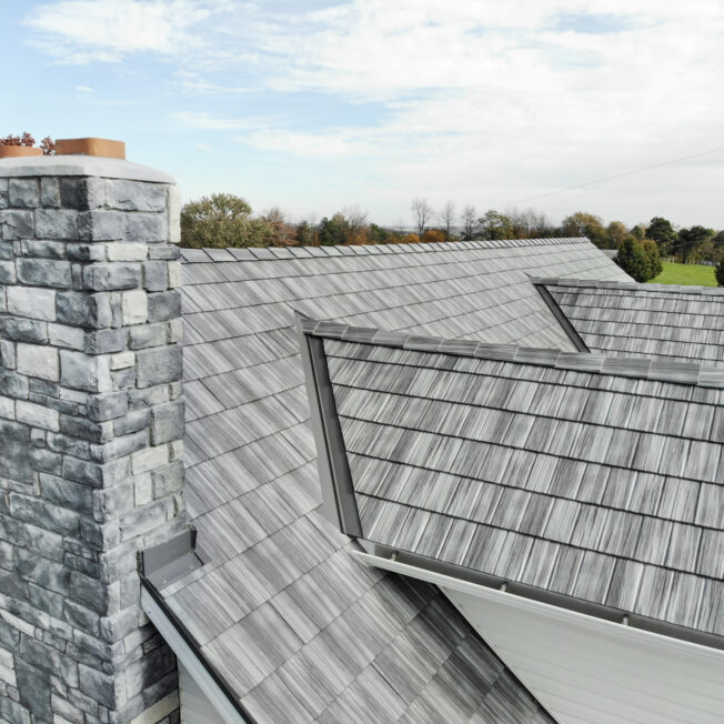 Close-up of blue and gray asphalt shingles arranged in a layered pattern.