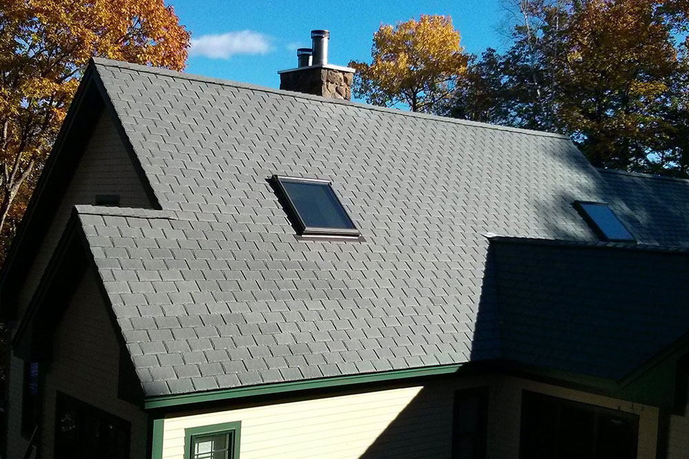 Close-up of blue and gray asphalt shingles arranged in a layered pattern.